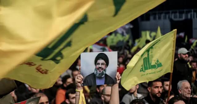 Partidarios del movimiento libanés Hezbolá, aliado de Irán, ondeaban banderas mientras asistían a una manifestación masiva y a un discurso televisado del secretario general de Hezbolá, Hassan Nasrallah, el 3 de enero de 2023 en Líbano, Beirut (Foto: Marwan Naamani/dpa vía ZUMA Press/APAIMAGES)