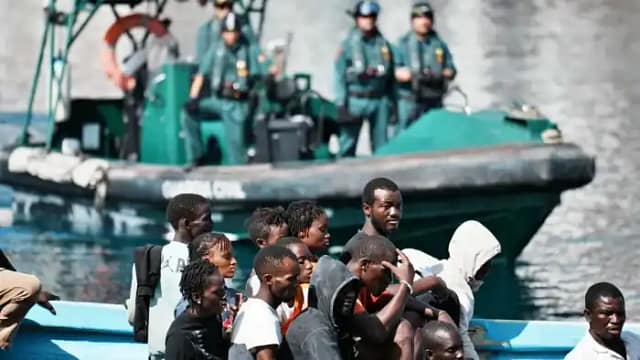 Foto de inmigrantes custodiados por fuerzas de seguridad