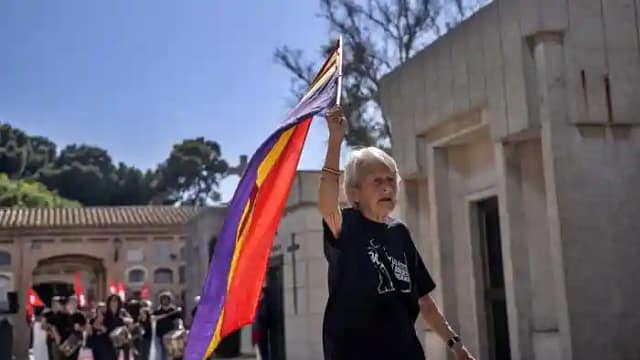 Mujer mayor con bandera republicana en el cementerio de València