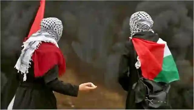 Foto de dos luchadoras palestinas portando banderas