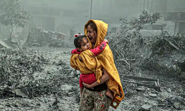 Una mujer con una niña en brazos tras los ataques aéreos israelíes que impactaron el barrio de Ridwan en la ciudad de Gaza. 23 de octubre de 2023.Ali Jadallah / Gettyimages.ru